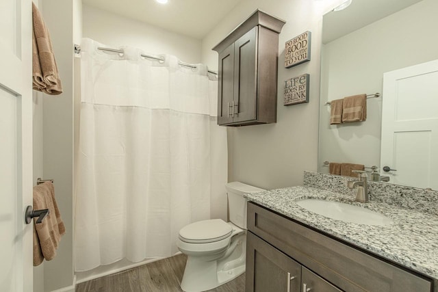 bathroom with vanity, toilet, and hardwood / wood-style floors