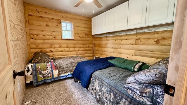 bedroom with carpet, log walls, and ceiling fan