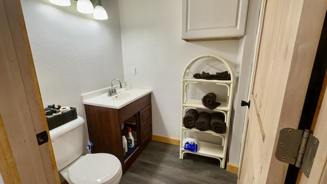 bathroom featuring toilet, hardwood / wood-style flooring, and vanity