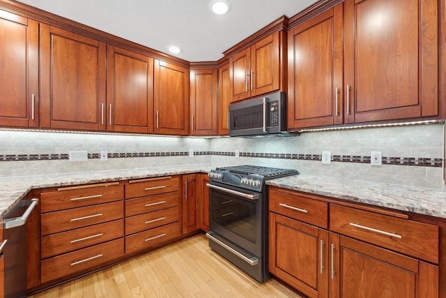 S2916A Fairway Dr, Reedsburg, WI 53959 - kitchen featuring appliances with stainless steel finishes, light hardwood / wood-style flooring, tasteful backsplash, and light stone counters