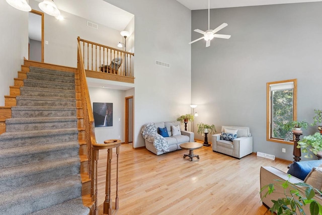 living room featuring ceiling fan, high vaulted ceiling, and light wood-type flooring