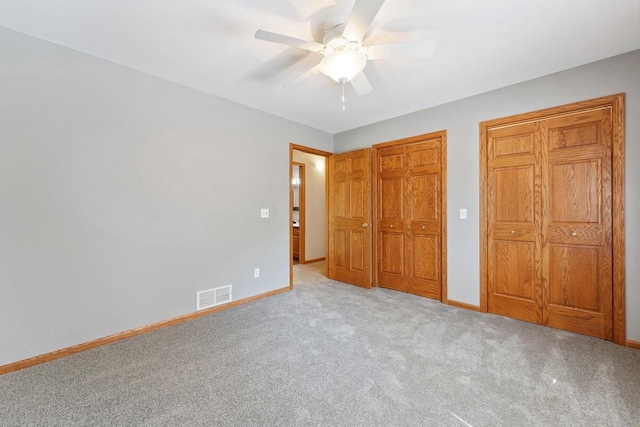 S2916A Fairway Dr, Reedsburg, WI 53959 - unfurnished bedroom with ceiling fan, multiple closets, and light carpet