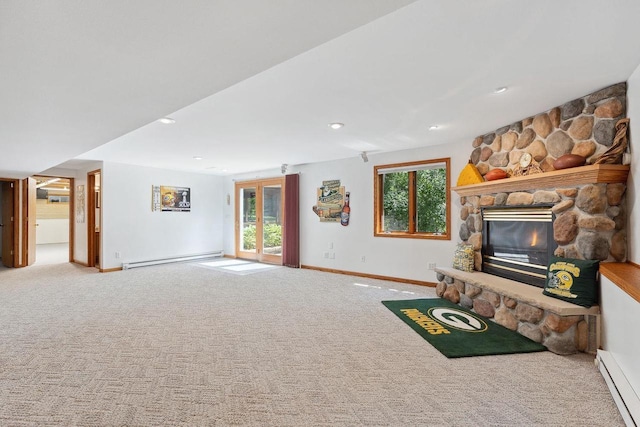 S2916A Fairway Dr, Reedsburg, WI 53959 - unfurnished living room with a baseboard radiator, plenty of natural light, carpet flooring, and a stone fireplace