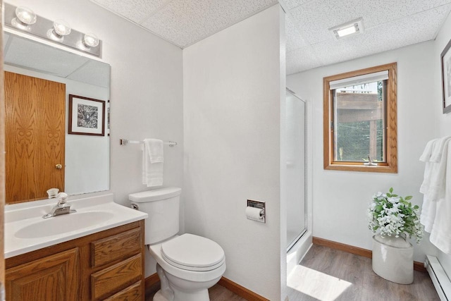 S2916A Fairway Dr, Reedsburg, WI 53959 - bathroom featuring baseboard heating, wood-type flooring, a shower with shower door, and vanity