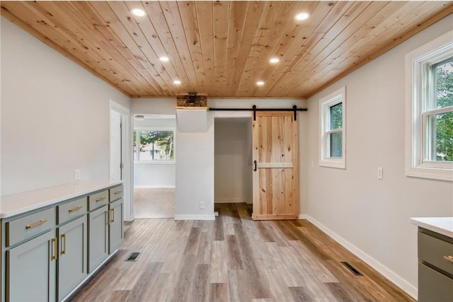 interior space with wood ceiling, light hardwood / wood-style flooring, a wealth of natural light, and a barn door