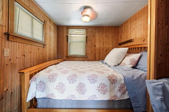 bedroom featuring wood walls