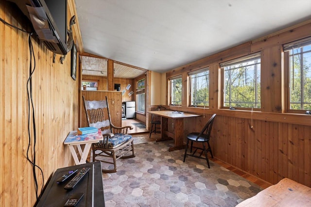 office area with vaulted ceiling and wood walls