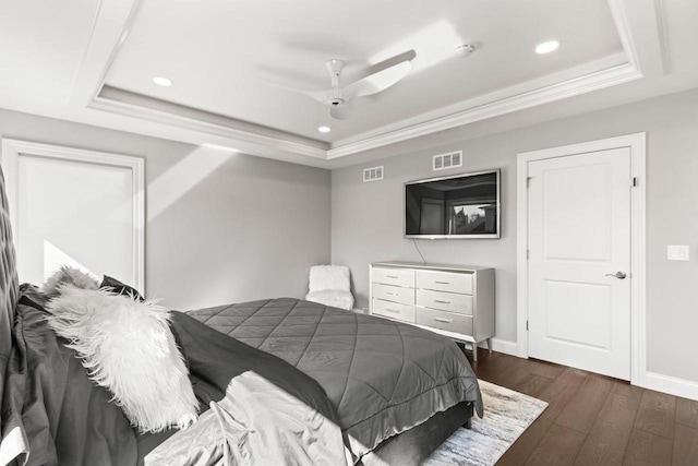 bedroom featuring a raised ceiling, dark wood-type flooring, and ceiling fan