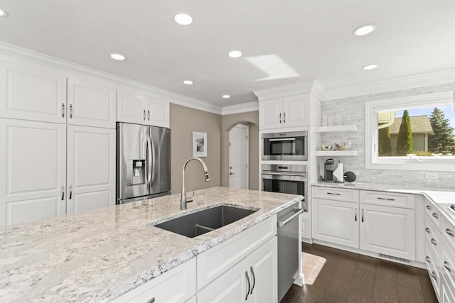 kitchen with light stone counters, sink, stainless steel appliances, and white cabinets