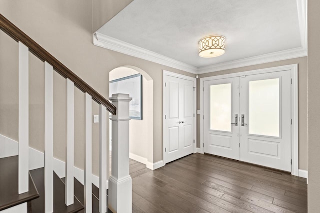 foyer featuring french doors, crown molding, and dark wood-type flooring