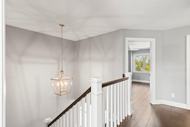 corridor featuring a notable chandelier and dark wood-type flooring