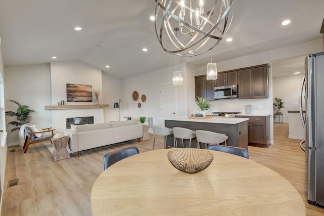 dining space featuring light wood-type flooring and lofted ceiling