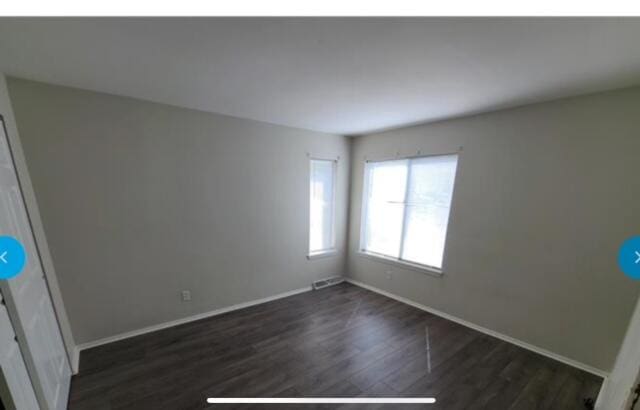 unfurnished room with dark hardwood / wood-style floors