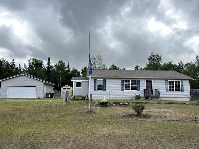 view of front of house with a front lawn, a storage shed, and a garage