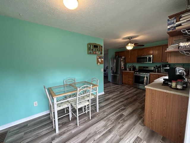 kitchen featuring a textured ceiling, stainless steel appliances, ceiling fan, and hardwood / wood-style flooring