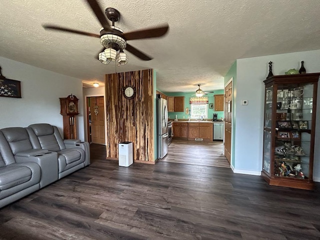 unfurnished living room featuring ceiling fan, a textured ceiling, sink, and wood-type flooring