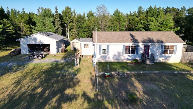 view of front of home with a front yard, a garage, and an outdoor structure