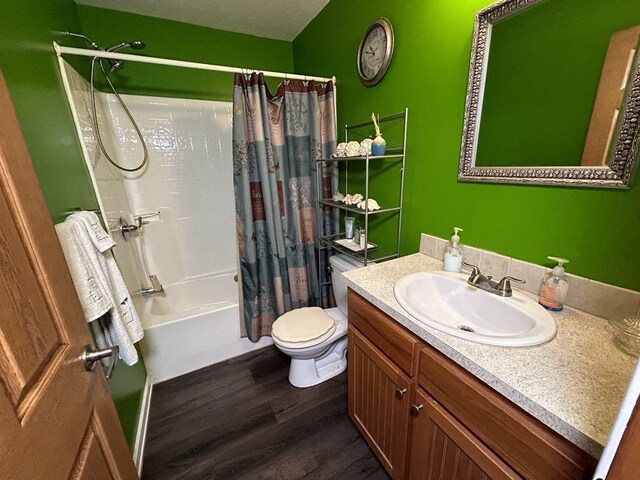 full bathroom featuring hardwood / wood-style floors, vanity, toilet, and shower / bath combo with shower curtain