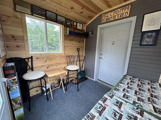 carpeted bedroom featuring lofted ceiling, wood ceiling, and wooden walls