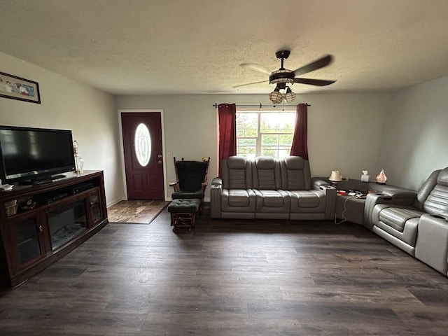 living room featuring dark hardwood / wood-style flooring, a textured ceiling, and ceiling fan