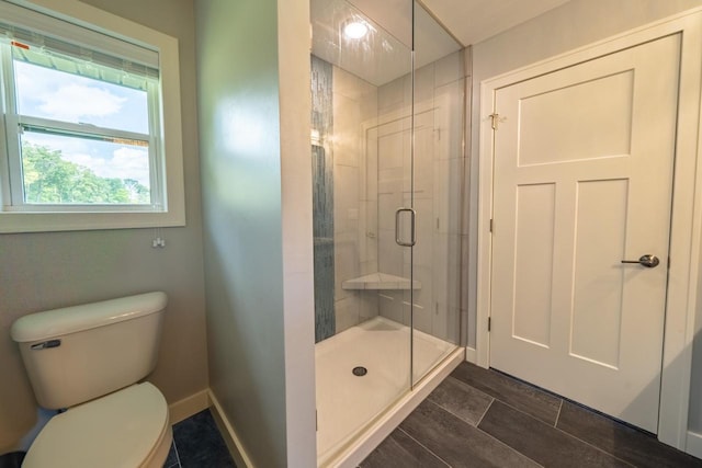 bathroom featuring toilet and a shower with door