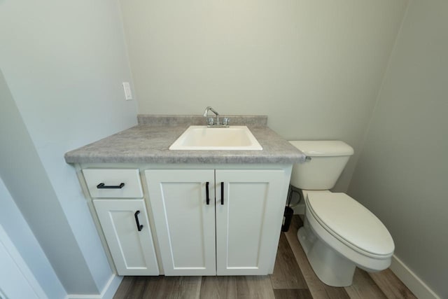 bathroom featuring toilet, vanity, and wood-type flooring