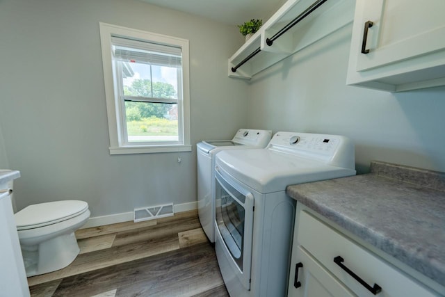 laundry room with hardwood / wood-style flooring and washer and dryer