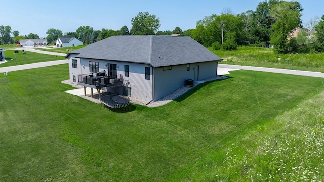 exterior space with a yard, a deck, and cooling unit