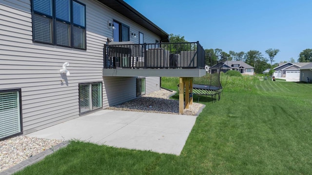 view of yard featuring a trampoline and a patio