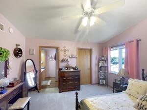 bedroom with ceiling fan, light colored carpet, and lofted ceiling