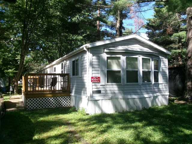 view of property exterior with a wooden deck and a lawn