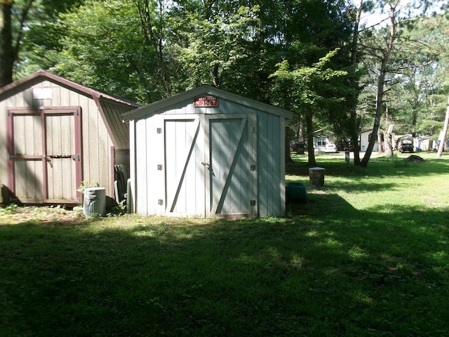 view of outbuilding featuring a yard and central AC