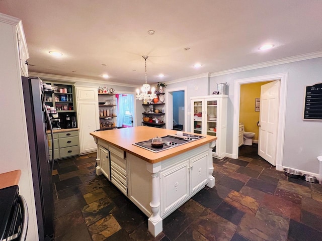 kitchen with white cabinets, a kitchen island, decorative light fixtures, and stainless steel fridge