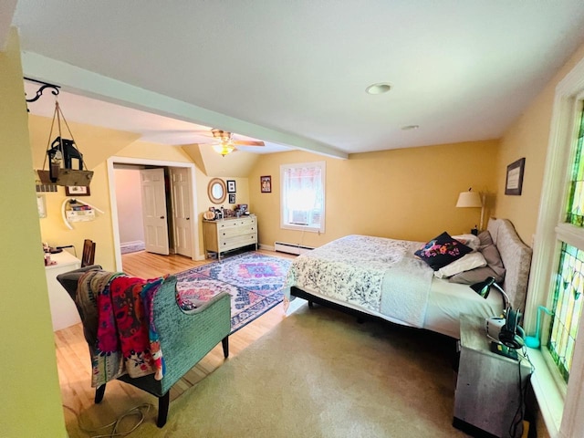 bedroom with a closet, wood-type flooring, lofted ceiling, ceiling fan, and baseboard heating