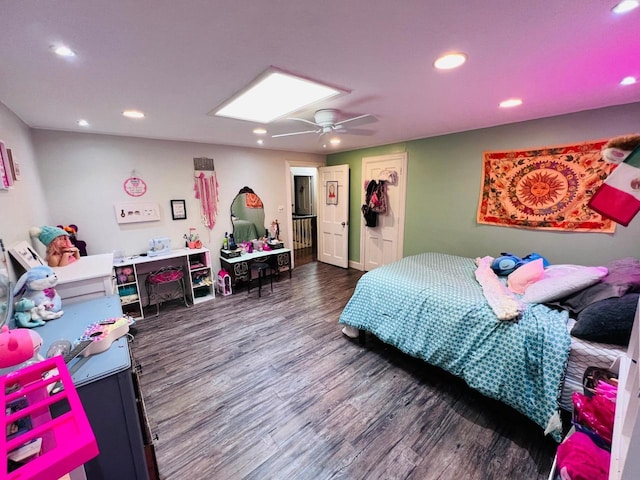 bedroom featuring ceiling fan, a skylight, and dark hardwood / wood-style floors