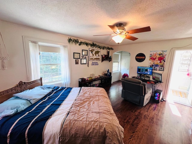 bedroom featuring ceiling fan, dark wood-type flooring, and a textured ceiling