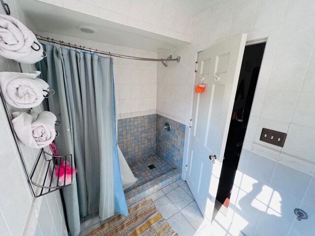 bathroom featuring tile walls, tile patterned flooring, and a shower with curtain