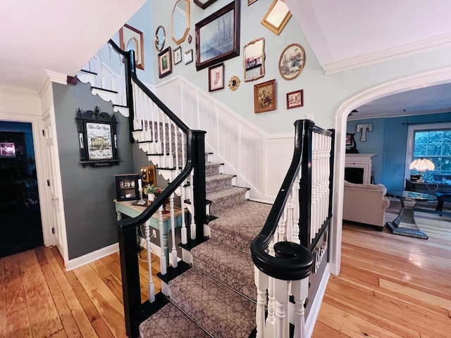 stairway featuring ornamental molding and hardwood / wood-style flooring