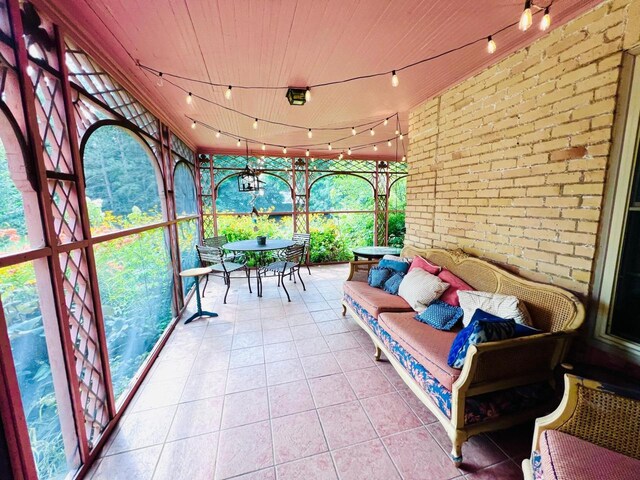 sunroom / solarium with track lighting and wooden ceiling