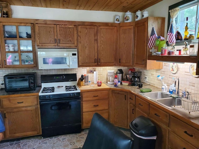 kitchen featuring backsplash, gas stove, wooden ceiling, and sink