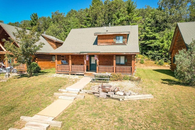 log-style house with a porch, a front lawn, and log siding