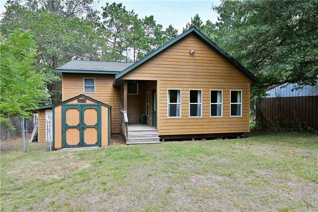 view of front of property featuring a shed and a front lawn