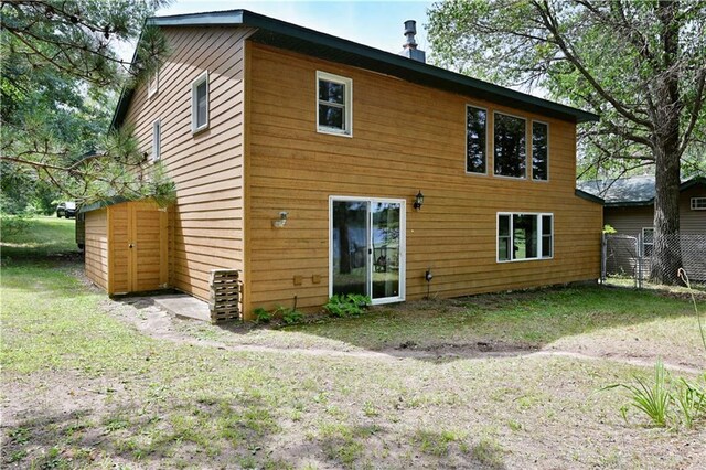 back of house featuring a lawn