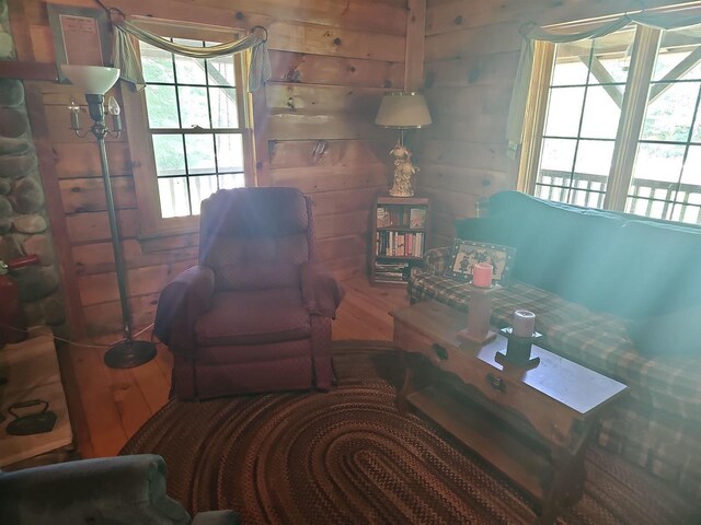 bedroom with ceiling fan, wooden walls, hardwood / wood-style floors, wooden ceiling, and lofted ceiling with beams