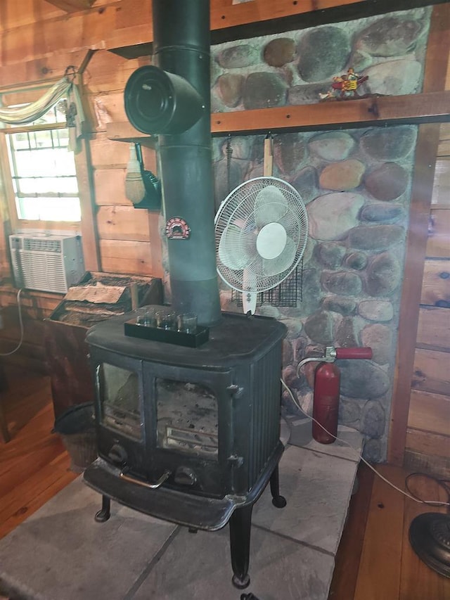 details with a wood stove and wood-type flooring