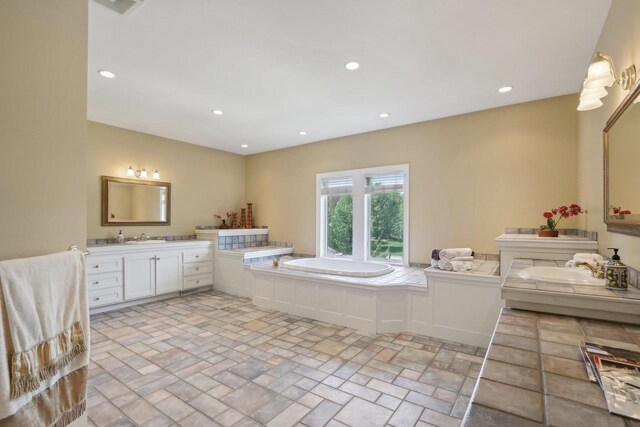 living area with light wood-type flooring, decorative columns, a high end fireplace, and ornamental molding