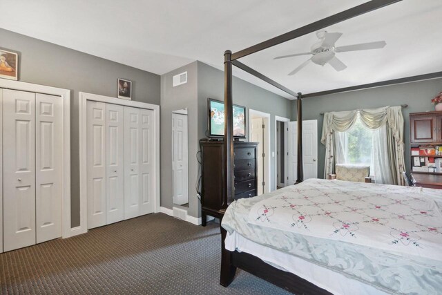 carpeted bedroom with ceiling fan and multiple closets