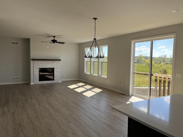 unfurnished living room with wood-type flooring and ceiling fan with notable chandelier