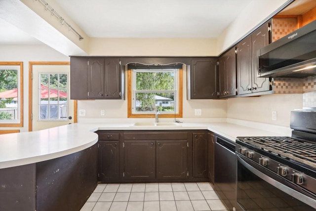 kitchen featuring dark brown cabinets, black appliances, a healthy amount of sunlight, and sink