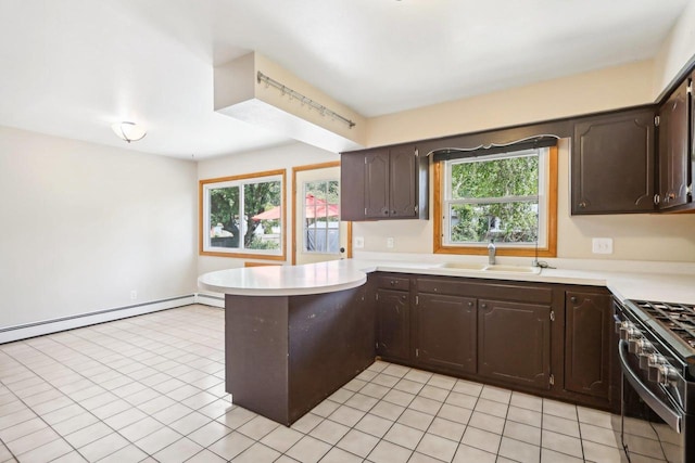 kitchen with dark brown cabinets, high end stove, plenty of natural light, and sink